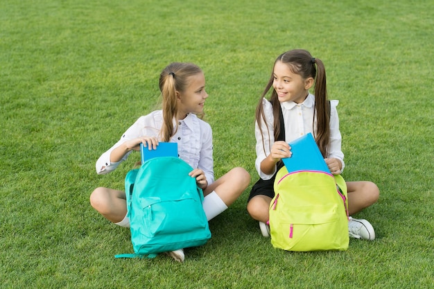 Group study outdoors girls classmates with backpacks, back to school concept.