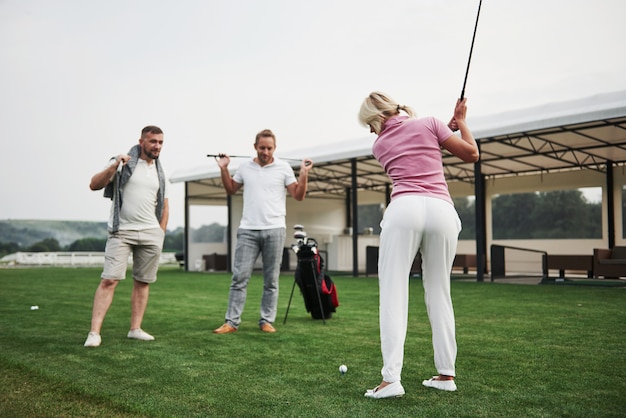 Group of stylish friends on the golf course learn to play a new game