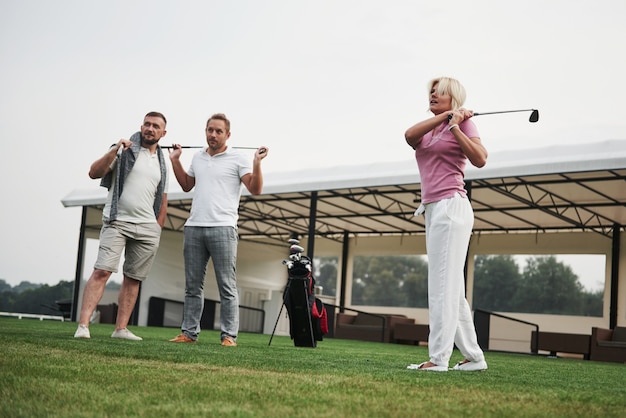 Group of stylish friends on the golf course learn to play a new game