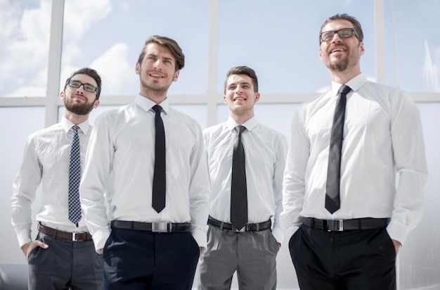 Group of successful business people standing near the window business concept