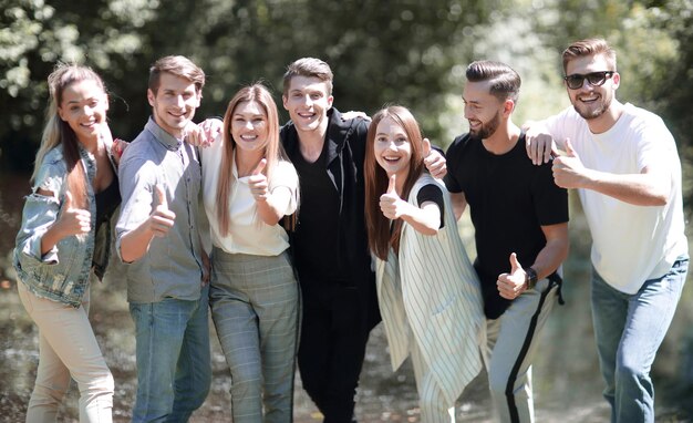 Group of successful young people showing thumb up