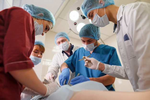 Группа хирургов делает операции в больнице.