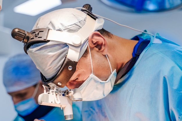 Photo group of surgeons in operating room with surgery equipment