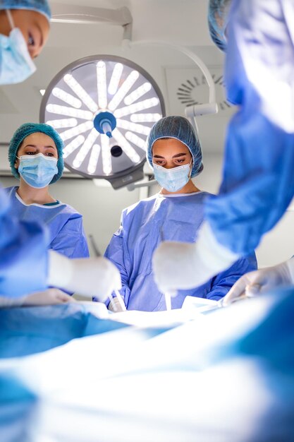 Group of surgeons wearing safety masks performing operation Medicine concept surgery medicine and people concept group of surgeons at operation in operating room at hospital