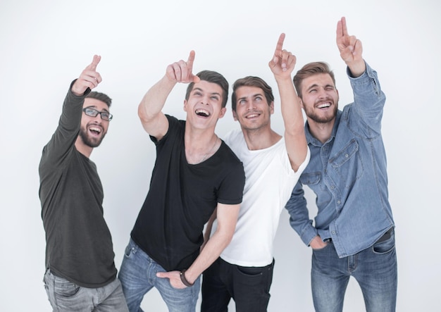 Group of surprised young people looking and pointing upisolated on white