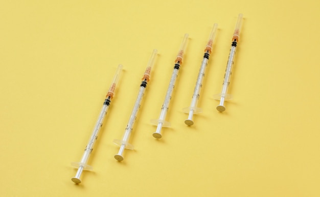 Group of syringes on yellow background. Diabetes injections concept.