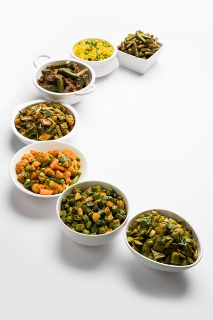 콜리플라워 또는 Phool Gobhi, bhindi 또는 okra, Gwar 또는 클러스터 콩, 프랑스 콩, 양배추 또는 Patta Gobi, 평평한 녹색 콩과 같은 Tawa 프라이 사브지 또는 사브지 그룹이 그릇에 제공됩니다. 선택적 초점