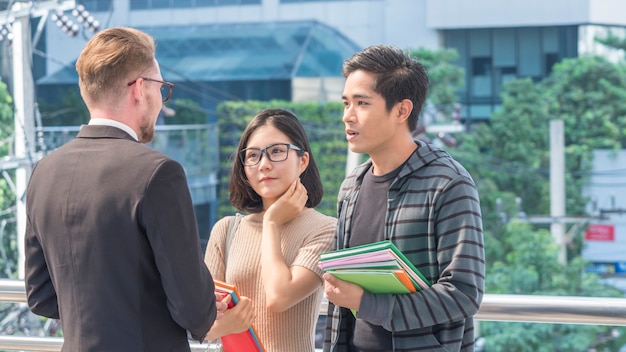 10代の教師と学生のグループが屋外で会って話す