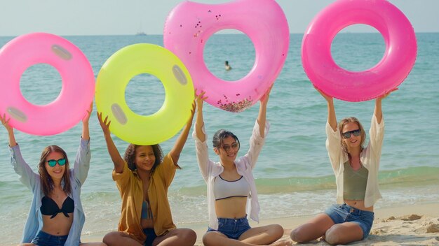 A group of teenage girls run and play at the beach for their summer vacation and they smile and enjoy their vacation