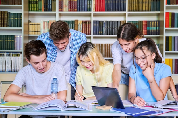 Group of teenage students study in library class