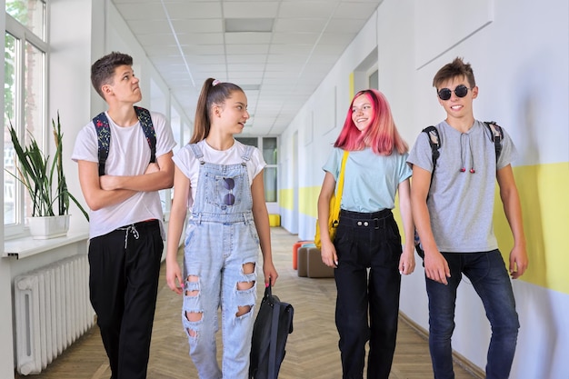 학교 복도를 따라 함께 걷는 10대 학생들의 그룹 학생들은 웃고 이야기하는 교육 고등학교 청소년기 개념