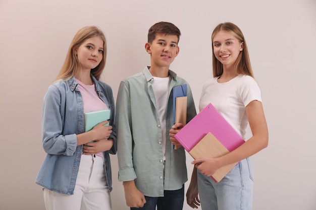 Group of teenage students with stationery on beige background