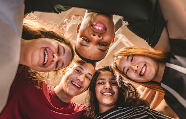 Group of teenager friends on a basketball court teamwork and togetherness concept