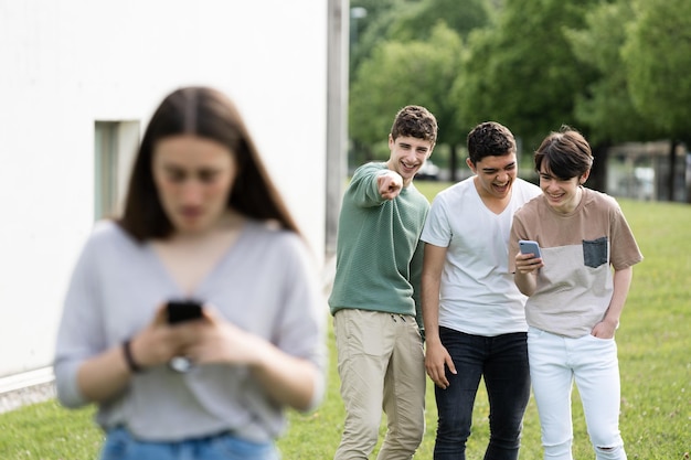 Group of teenager friens laughing at girl