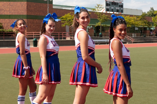 Photo group of teenagers in cute cheerleader uniform