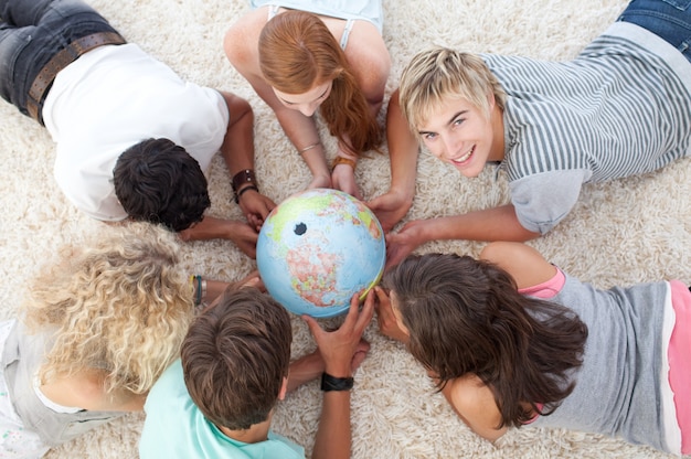 Group of teenagers on the floor examining a terrestrial world