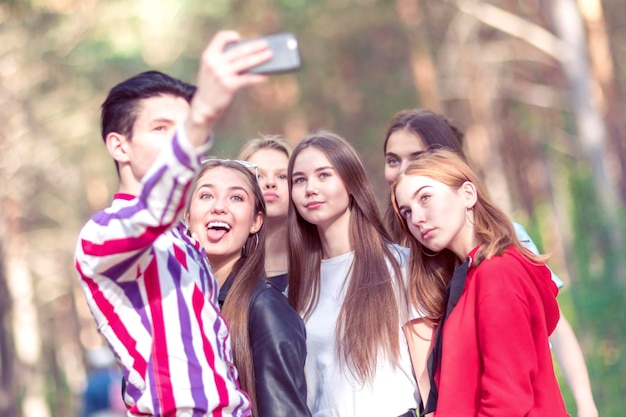 A group of teenagers making selfie in the forest Summer sunny day