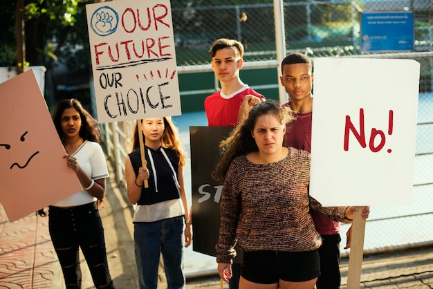 Group of teenagers protesting demonstration holding posters antiwar justice peace concept