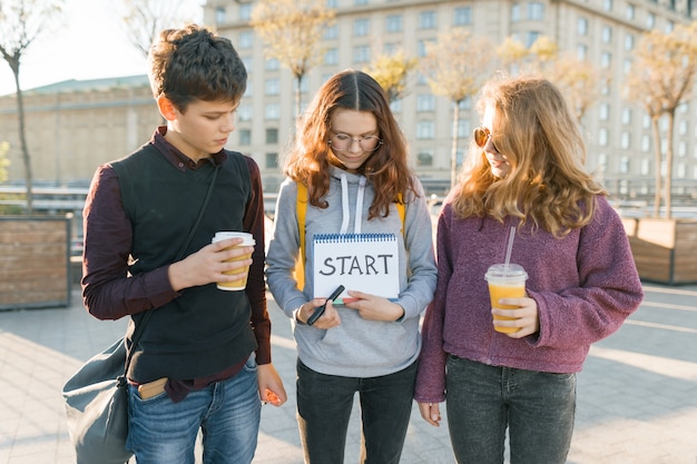 Group teenagers with notepad with handwritten word start