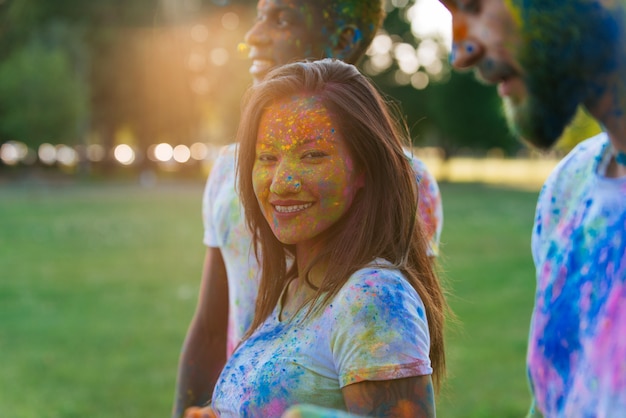 Group of teens playing with colors at the holi festival, in a park