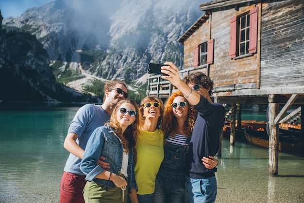 Group of teens spending time on the lake beach