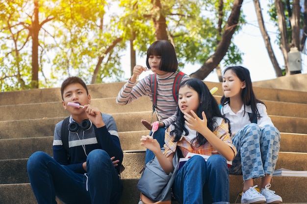 Group of thai students eating ice cream ice-cream sitting at campus	
