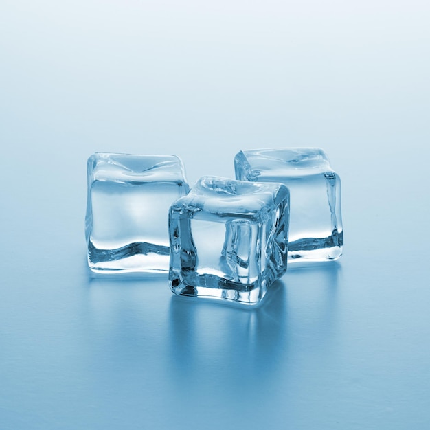 A group of three Crystal clear ice cubes on gradient background. Taken in Studio with a 5D mark III.