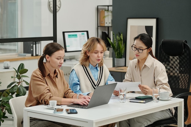 group of three female entrepreneurs discussing work at business meeting