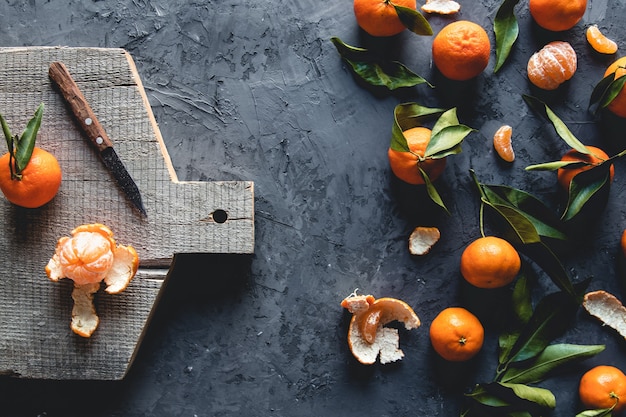 Gruppo di tre interi un pezzo di mandarino arancia fresco sul tagliere di legno. eco vegetarianismo. pnov2019