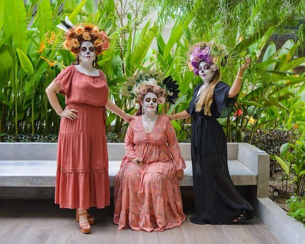 Group of three women showing catrinas make up. Makeup for the celebration of Day of the Dead.