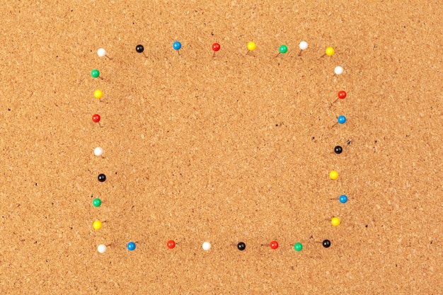 Group of thumbtacks pinned on corkboard