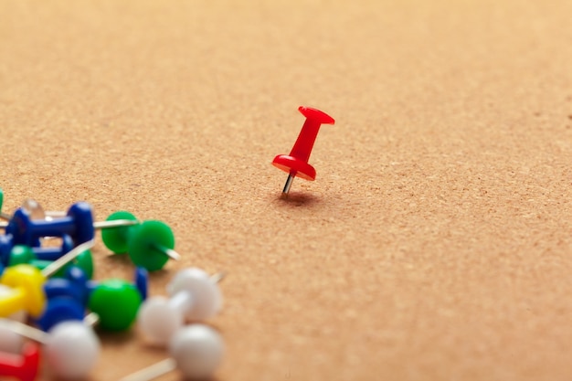 group of thumbtacks pinned on corkboard