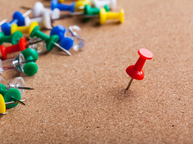 Group of thumbtacks pinned on corkboard