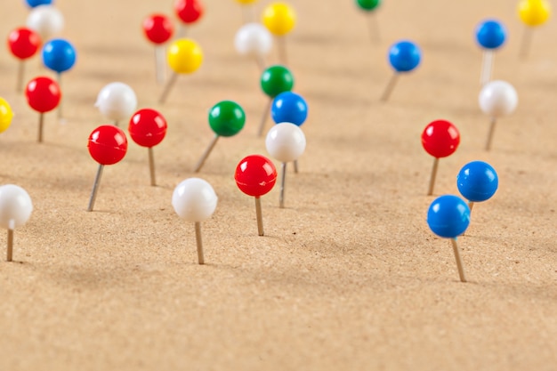 Group of thumbtacks pinned on corkboard