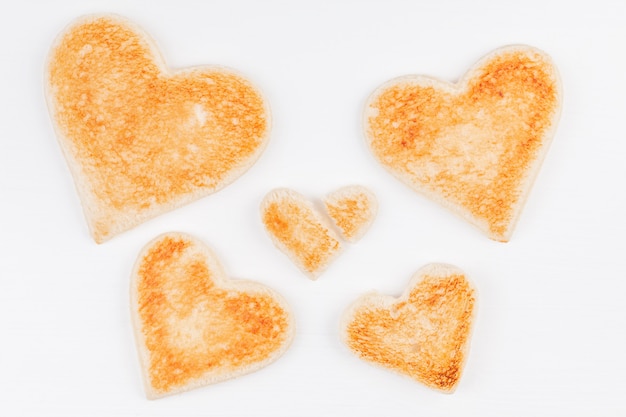 Группа поджаренного хлеба сердца с одним разбитым сердцем вместе на белом фоне
