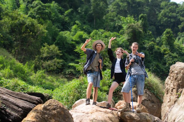 Group of tourists with backpacks walking on the trail in the river and mountains