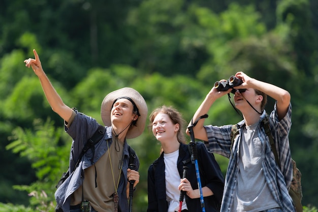 Group of tourists with backpacks walking on the trail in the river and mountains