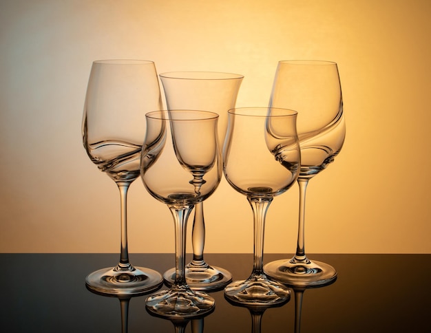 A group of transparent wine glasses on a colored luminous\
background