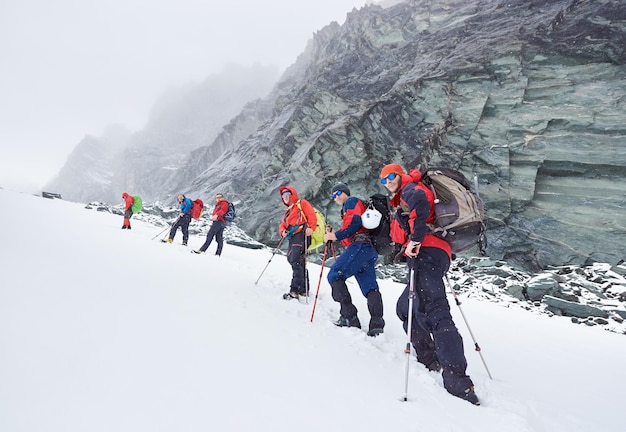 冬の山でハイキングする旅行者のグループ。