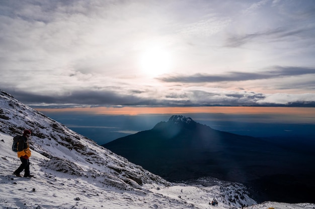 Group of trekkers hiking among snows and rocks of Kilimanjaro mountain