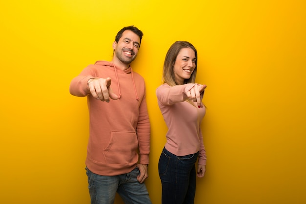  Group of two people on yellow background points finger at you 