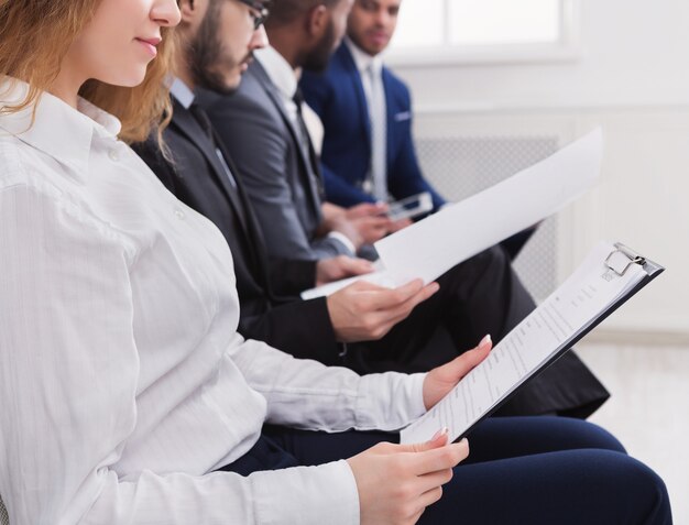 Group of unemployed applicants sitting on chairs and waiting for interview