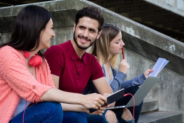 屋外で一緒に勉強している大学生のグループ