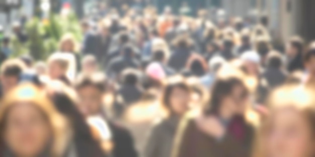 Photo group of unrecognizable anonymous people in bokeh walking on a street defocused image