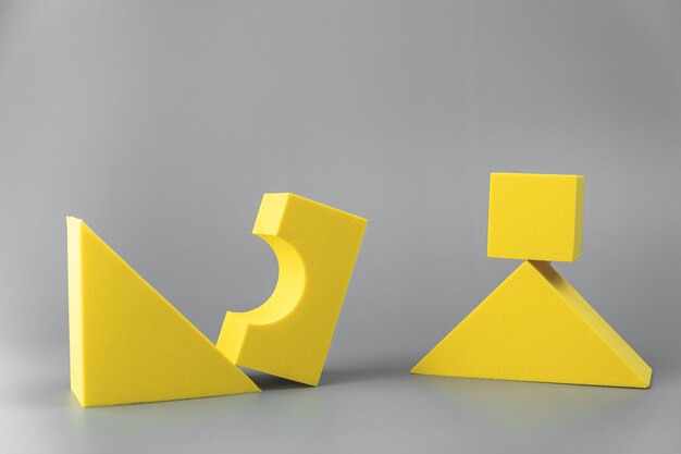 Foto gruppo di forme geometriche gialle volumetriche su uno sfondo grigio forme semplici