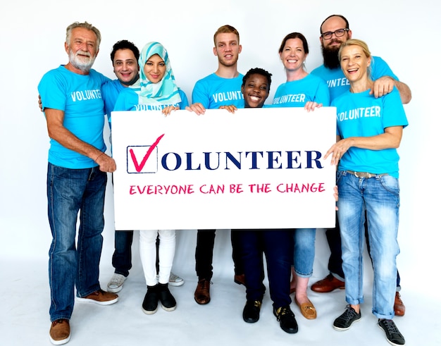 Photo group of volunteer people smiling and holding charity banner