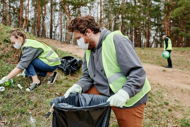 Group of Volunteers Collecting Trash in Forest