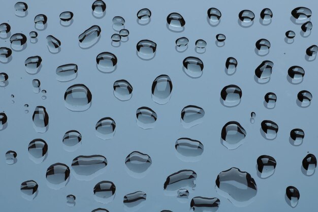 Photo group of water drops on a glass  light blue background