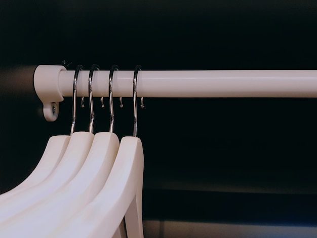 Group of White Cloth Hangers Hanging on the Rack Inside the Wardrobe