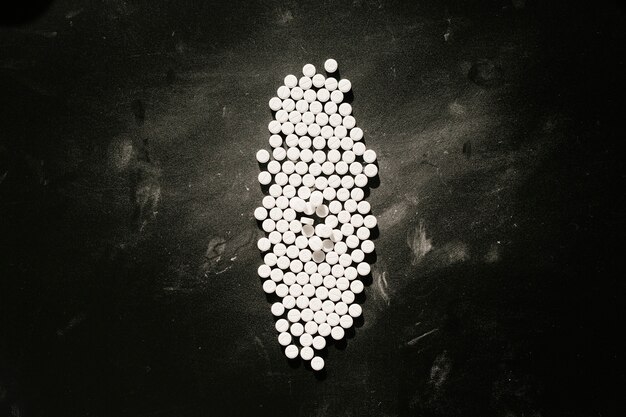 Group of white pills on a black table